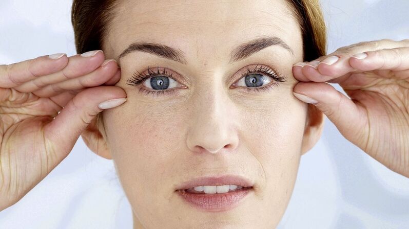 A woman holds her hands close to the eyes